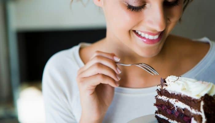 Woman eating chocolate cake as a natural remedy for pregnancy headache