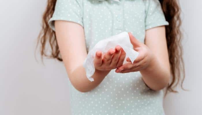 baby wipe is used by a girl to wipe hands